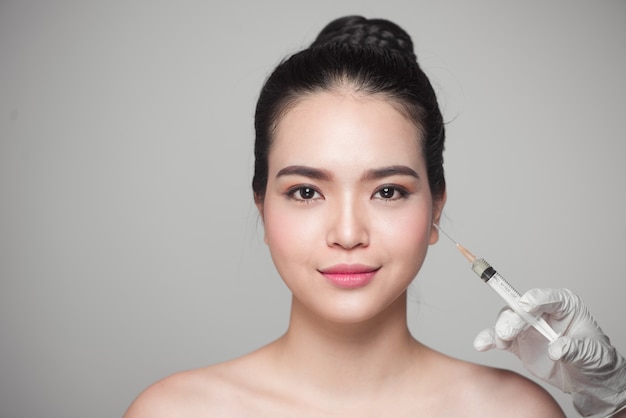 Beautiful asian woman gets beauty facial injections. Face aging injection