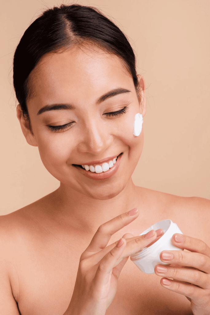 Woman applying face cream as part of an aesthetic skincare treatment
