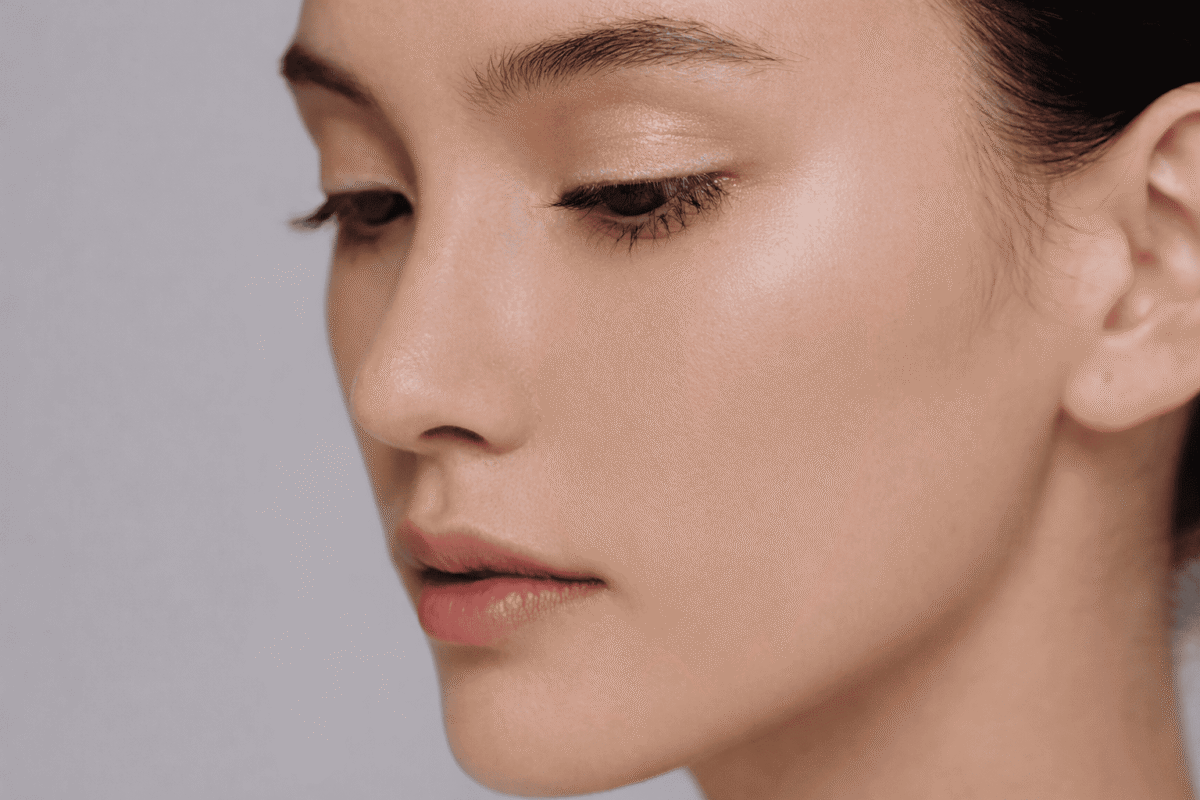 Side profile portrait of an Asian woman with clear skin and soft lighting