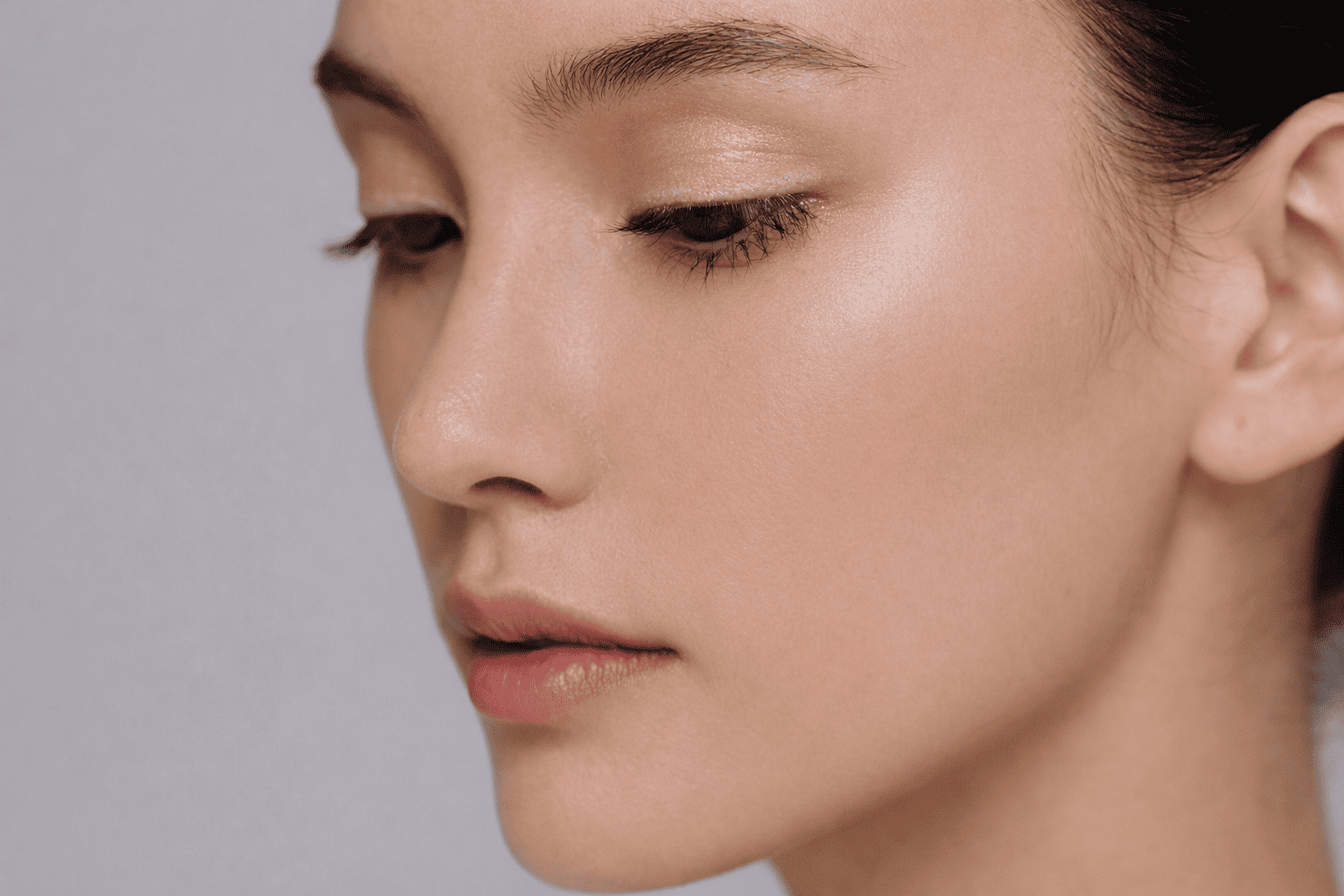 Side profile portrait of an Asian woman with clear skin and soft lighting