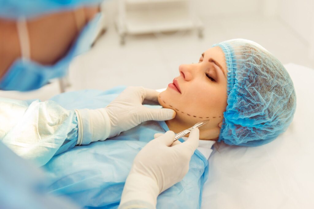 Surgeon performing facelift treatment on woman with marked jawline in operating room